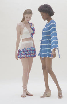 video of  white crochet bralette and matching skirt with blue and red ruffle detail